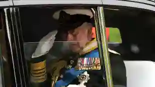 King Charles III sitting in a car with the window down