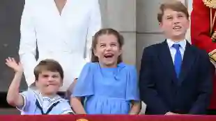 Prince Louis, Princess Charlotte and Prince George stand side by side on the balcony of Kensington Palace during Queen Elizabeth II's Jubilee.