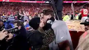 Taylor Swift and Travis Kelce kissing on the pitch