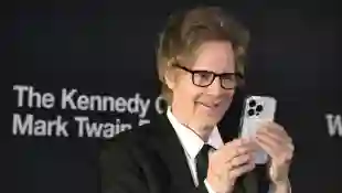 Comedian Dana Carvey uses his phone to take pictures of the photographers as he arrives on the red carpet for the 2023 K