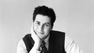 Corey Parker smiles cross-legged