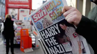 A man reads the newspaper "The Sun" in L
