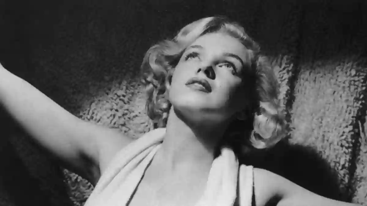 circa 1952: Portrait of American actor Marilyn Monroe (1926 - 1962) wearing a lowcut halter top on a carpet.