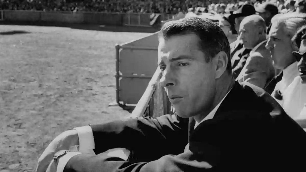 Ex-Yankee  baseball  player  Joe  DiMaggio,  leaning  over  rail  watching  3rd  game  of  the  Worl