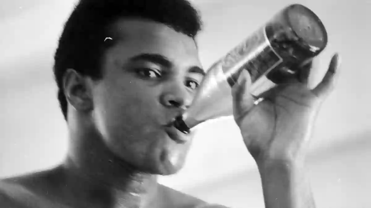 A  close-up  of  professional  boxer  Muhammad  Ali  having  a  drink  during  his  training  for  t