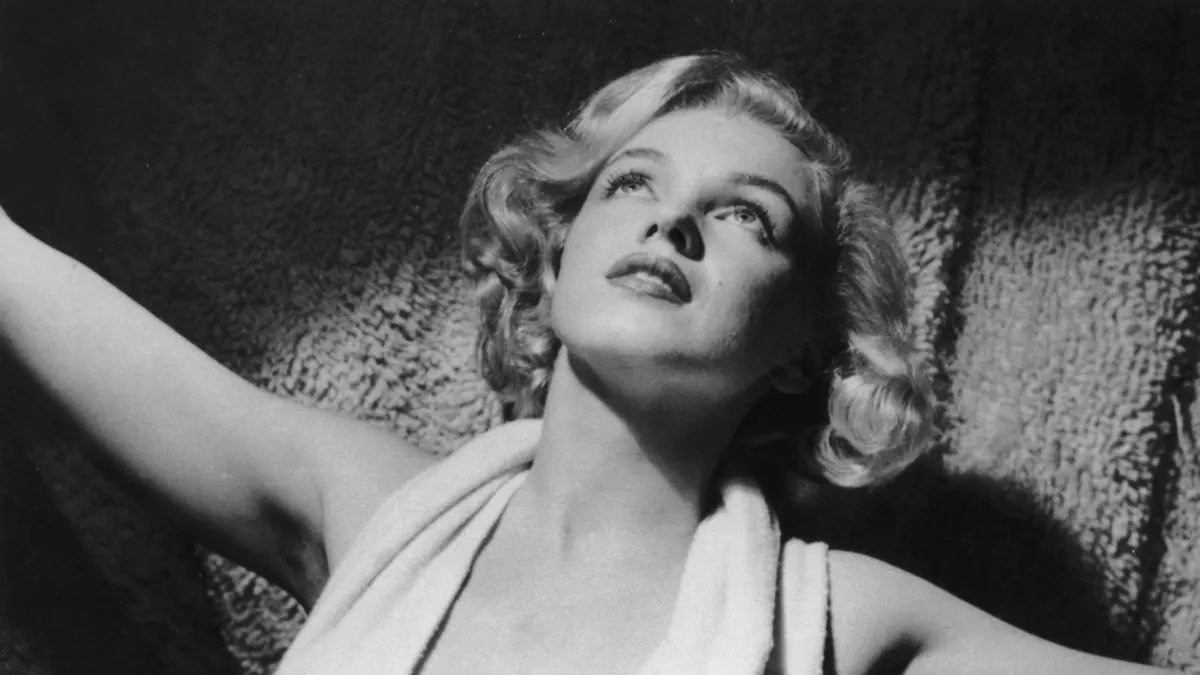 circa 1952: Portrait of American actor Marilyn Monroe (1926 - 1962) wearing a lowcut halter top on a carpet.