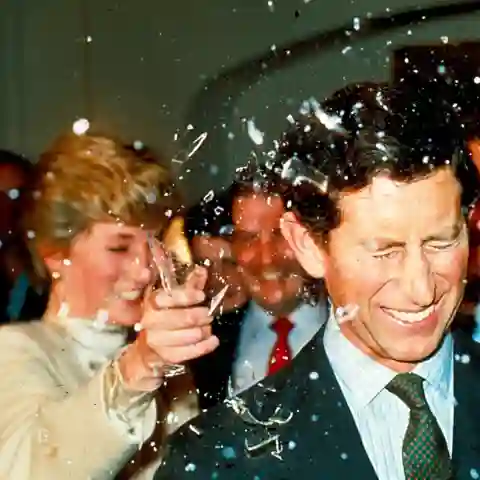 Princess Diana breaks a sugar glass bottle over her husband's head at Pinewood Studios to watch the making of the latest James Bond films on 11 December 1986.