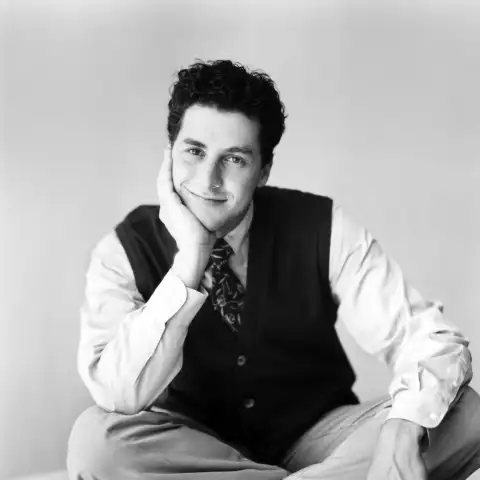 Corey Parker smiles cross-legged