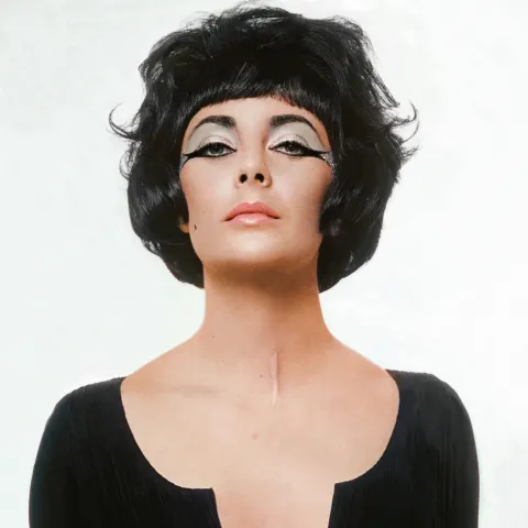 Actor Elizabeth Taylor in a studio, wearing a costume intended to evoke her role in the movie Cleopa
