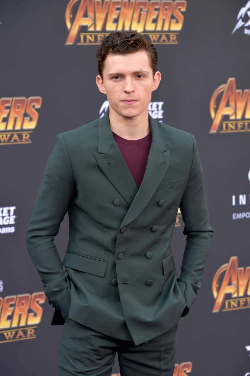 tom holland playing with avengers figurines