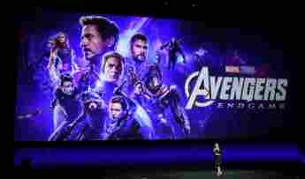 Disney Executive Cathleen Taff speaks in front of the Avengers movie poster during the 2019 CinemaCon presentation.