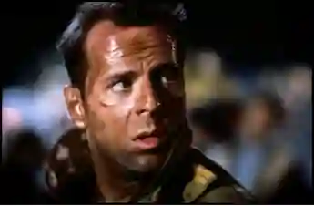 Bruce Willis as "John McClane" in Die Hard.