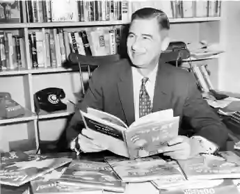 Ted Geisel (Dr. Seuss) (1904-1991) seated at desk covered with his uniquely humorous children s books. 1957. Courtesy E