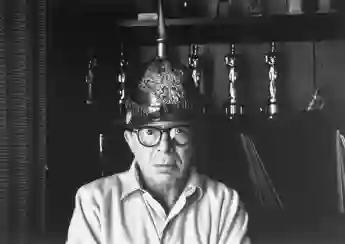 Le réalisateur Billy Wilder dans son bureau à Hollywood, portant un casque allemand avec des Oscars sur une étagère.