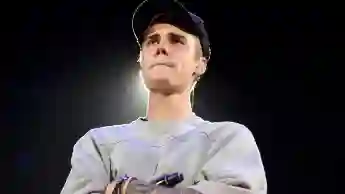 Justin Bieber stands on stage with his arms crossed in November 2015.