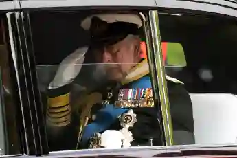 King Charles III sitting in a car with the window down