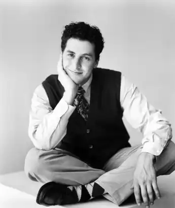 Corey Parker smiles cross-legged