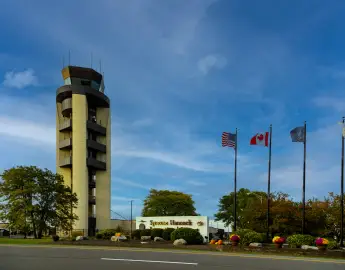 Syracuse, NY - September 28, 2023: Syracuse Hancock International Airport sign and control tower. Mo