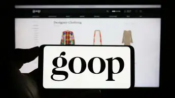 Person holding cellphone with logo of US publishing and e-commerce company Goop Inc. on screen. Stuttgart, Germany - 06-