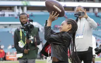 Jay-Z and Beyonc} s daughter Blue Ivy Carter warms up with a football before Super Bowl LIV at the Hard Rock Stadium in