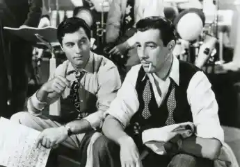 American actors George Montgomery and Cesar Romero in the movie Orchestra Wives, USA 1942 PUBLICATIONxNOTxINxITA