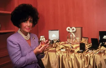 Actress  Elizabeth  Taylor  holding  bottle  of  her  perfume.DMI/The  LIFE  Picture  Collection