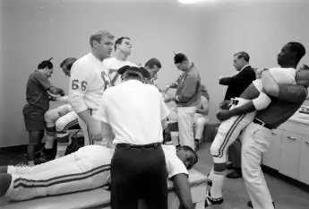 In  the  locker  room,  various  members  of  the  Kansas  City  Chiefs  football  team  are  massag