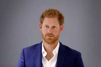 Prince Harry stands against a gray background in September 2017