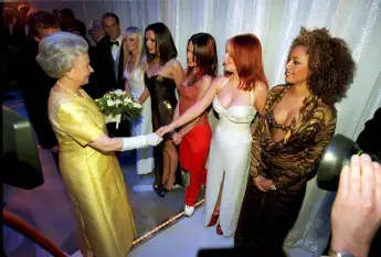 Queen Elizabeth II shakes hands with Geri Halliwell (Ginger Spice) of the pop group Spice Girls, December 1, 1997.