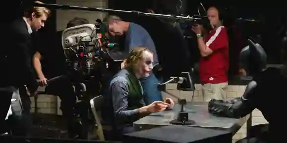 EL CABALLERO OSCURO, en el extremo izquierdo: el director Christopher Nolan; en primer plano desde la izquierda: Heath Ledger como Joker, Christian Bale como Ba