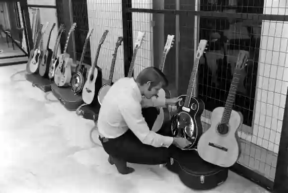 Le chanteur de country Glen Campbell inspectant l'une des guitares de sa collection, Los Angel