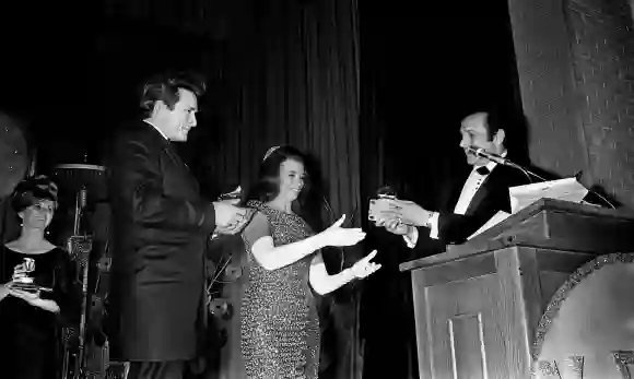 Syndication: The Tennessean, Johnny Cash, left, looks on as wife June Carter accepts her award for Best Country and West