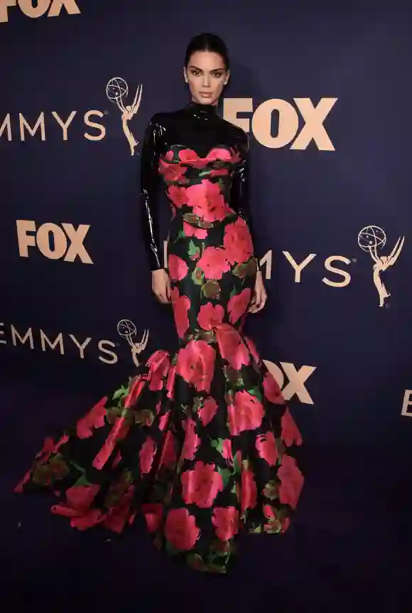 Por lo menos en el 2019 no cometió el mismo error durante los Emmy, donde luce un peinado limpio y tanto un vestido de sirena pomposos (apto para los Emmy) y un traje de látex correspondiente con los Jenner. Lamentablemente estos dos no combinan nada bien y terminó con un look muy extraño.