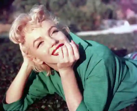 L'actrice Marilyn Monroe pose pour un portrait allongée sur l'herbe en 1954 à Palm Springs, Californie.