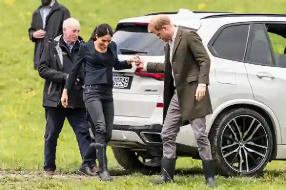 Le prince Harry (à droite) aide son épouse Meghan, duchesse de Sussex, alors qu'ils arrivent pour dévoiler une plaque dédiant 20 hectares de buissons indigènes au projet Queen's Commonwealth Canopy au North Shore Riding Club d'Auckland, le 30 octobre 2018. - Meghan Markle a fait preuve d'un talent inattendu pour le "welly wanging" à Auckland le 30 octobre, gagnant des droits de vantardise sur son mari le prince Harry après qu'ils se soient affrontés dans ce sport néo-zélandais étrange. (Photo by STR / POOL / AFP) (Photo credit should read STR/AFP via Getty Images)