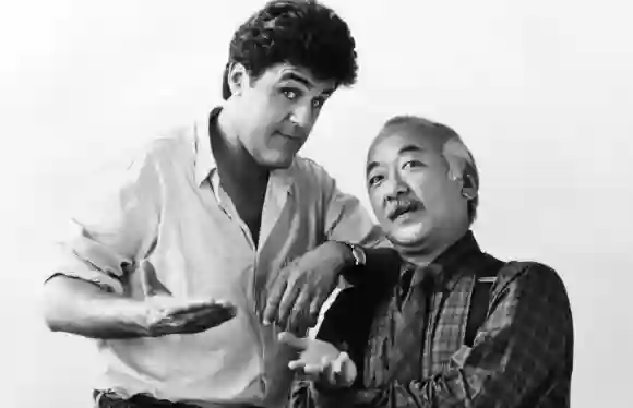 COLLISION COURSE, from left: Jay Leno, Pat Morita, 1989, © De Laurentiis Entertainment Group/courtesy Everett Collectio