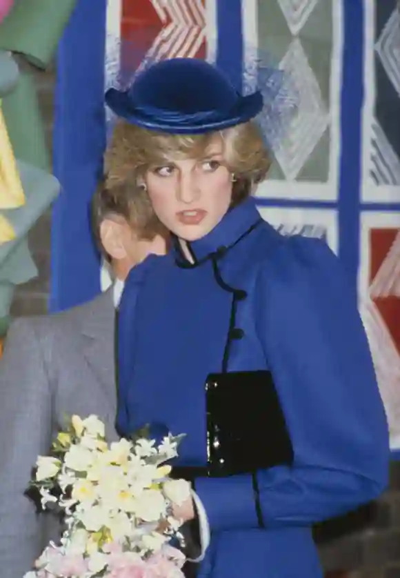 British Royal Diana, Princess of Wales (1961-1997), wearing a blue coat with black trim and a high neck, and a matching hat with netting, carrying a small bouquet of flowers during a visit to Brookfields Special School in Tilehurst, a suburb of Reading, Berkshire, England, 25th February 1983. (Photo by Keystone/Hulton Archive/Getty Images)
