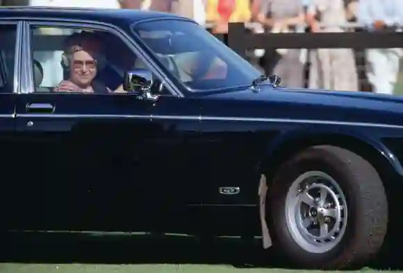 La Reine conduit une voiture Daimler Jaguar pour se rendre à un match de polo à Windsor.