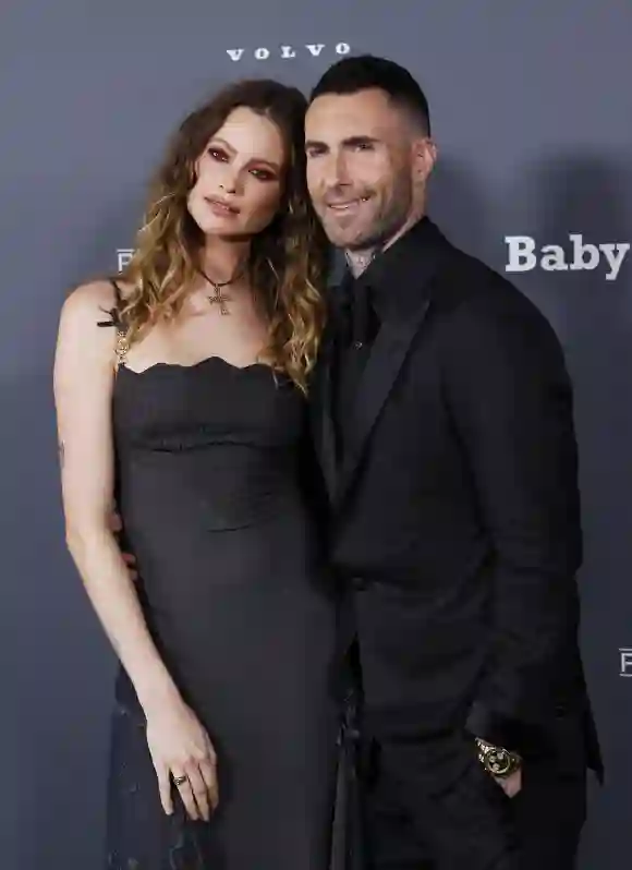 Adam Levine y Behati Prinsloo tomados del brazo en un evento en 2021