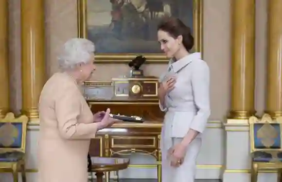L'actrice Angelina Jolie reçoit l'insigne d'une Dame Grand-Croix honoraire de l'Ordre très distingué de Saint-Michel et Saint-Georges de la part de la reine Élisabeth II, le 10 octobre 2014.