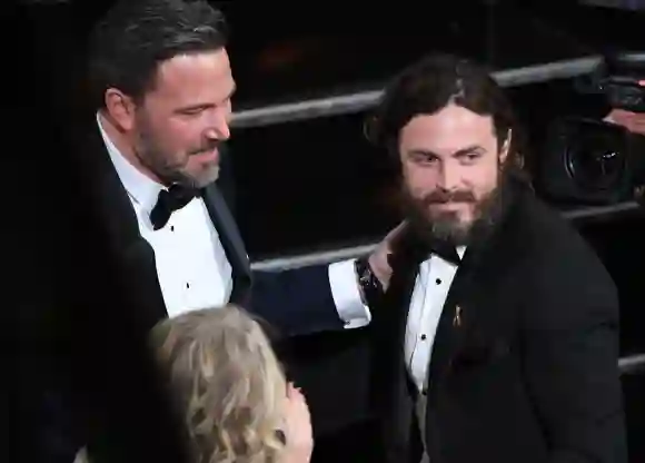 Casey Affleck is embraced by his brother Ben Affleck on stage at the 89th Oscars, February 26, 2017.