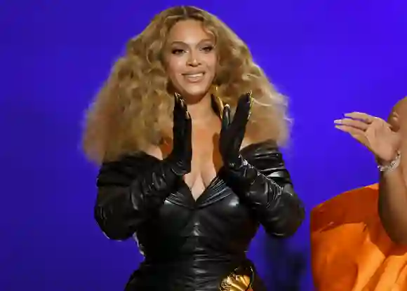 Beyoncé aplaude con sus manos, en las que lleva guantes negros