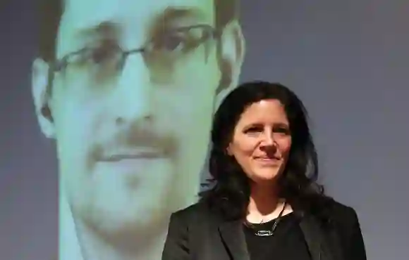 Laura Poitras stands on the stage as whistleblower Edward Snowden is seen on a video conference screen during an award ceremony on December 14, 2014 in Berlin, Germany.