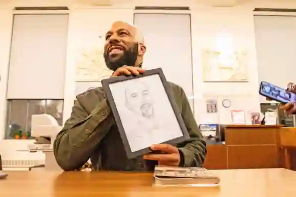 Syndication: Wilmington News Journal Common, rapper, actor, writer and activist, holds up a drawing of himself gifted by