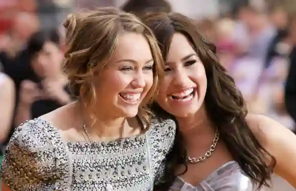 Miley Cyrus and Demi Lovato greet each other on April 23, 2009, at the British Premiere of Cyrus's latest film, Hannah Montana.