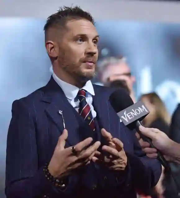 Tom Hardy speaks with television reporters as he attends the premiere of Venom at the Regency Village Theater in Los An