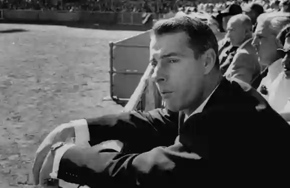 Ex-Yankee  baseball  player  Joe  DiMaggio,  leaning  over  rail  watching  3rd  game  of  the  Worl