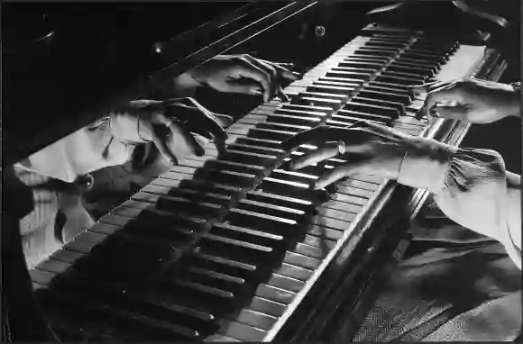 Close-up of the hands (and their reflected image) of jazz pianist Mary Lou Williams on a keyboard du