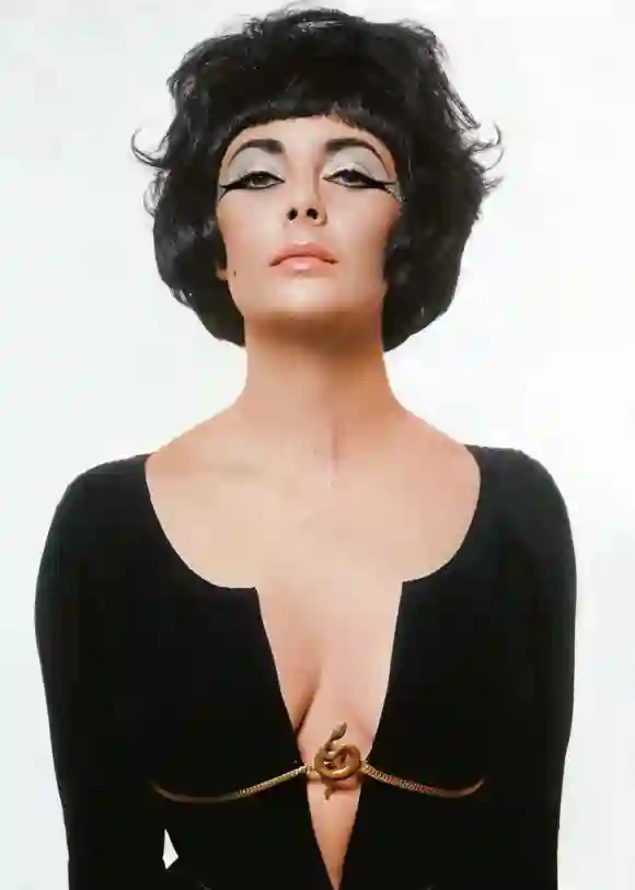 Actor Elizabeth Taylor in a studio, wearing a costume intended to evoke her role in the movie Cleopa