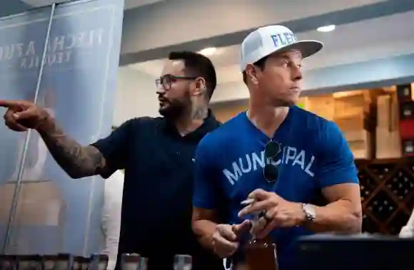 Syndication: Palm Beach Daily News Chef Lawrence Duran helps Mark Wahlberg during a bottle-signing event for Flecha Azul